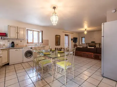 a kitchen with a table and chairs and a refrigerator at Holiday Home Migone de Sampolo by Interhome in Ghisoni