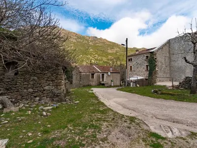 an old stone building next to a dirt road at Holiday Home Migone de Sampolo by Interhome in Ghisoni