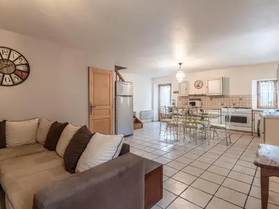 a living room with a couch and a kitchen at Holiday Home Migone de Sampolo by Interhome in Ghisoni