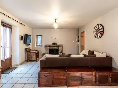 a living room with a large couch and a fireplace at Holiday Home Migone de Sampolo by Interhome in Ghisoni