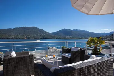 a balcony with chairs and a view of the water at Le Neptune & Spa in Propriano