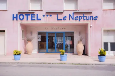 a hotel with large vases in front of a building at Le Neptune & Spa in Propriano