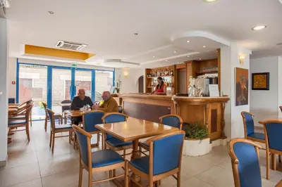 two people sitting at tables in a restaurant at Le Neptune & Spa in Propriano