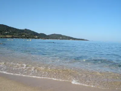 a beach with a body of water with mountains in the background at Hotel Celine in Coti-Chiavari
