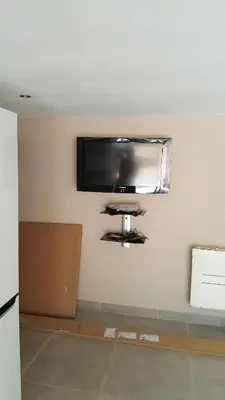 a flat screen tv hanging on a wall at Rez de Villa in Loreto-di-Tallano