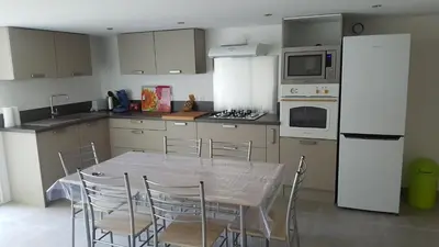 a kitchen with a table and chairs in a kitchen at Rez de Villa in Loreto-di-Tallano
