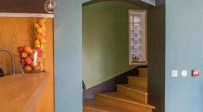 a room with stairs and a vase of fruit on the wall at Rossi Hôtel in Sartène