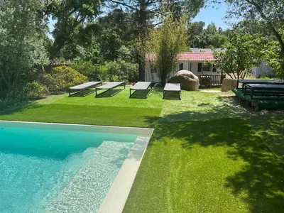 a backyard with a pool with benches on the grass at Les Bergeries de Petralonga in Sotta