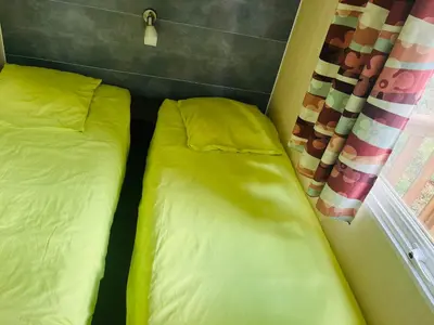 two beds in a small room with a window at Les Bergeries de Petralonga in Sotta