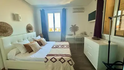 a bedroom with a white bed and a window at Hôtel Les 3 Terrasses in Sari Solenzara