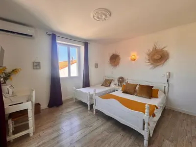 a bedroom with two beds and a window at Hôtel Les 3 Terrasses in Sari Solenzara