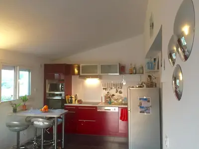 a kitchen with red cabinets and a white refrigerator at Casa Nelly in Porticcio