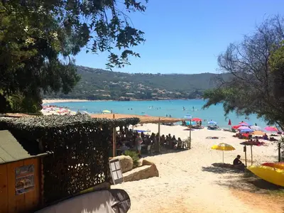 a beach with a bunch of people on the beach at Casa Nelly in Porticcio