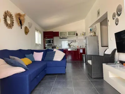 a living room with a blue couch and a kitchen at Casa Nelly in Porticcio