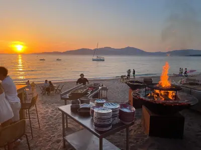 a beach with a table with plates and fires on it at Casa Nelly in Porticcio