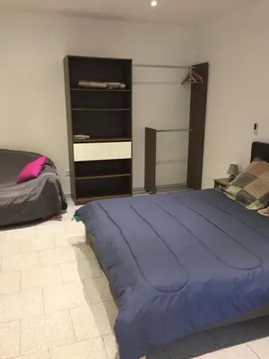a bedroom with a large blue bed and a dresser at Ernella in Aléria