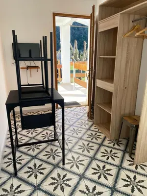 a room with a chair and a table on a tiled floor at Ernella in Aléria