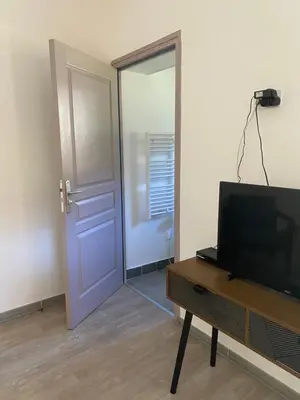 a room with a door and a television and a table at Ernella in Aléria