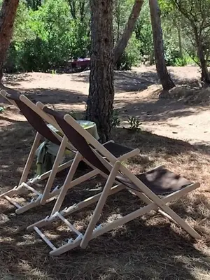 a stack of chairs sitting next to a tree at Tente Lodge Bord de Mer in Coti-Chiavari