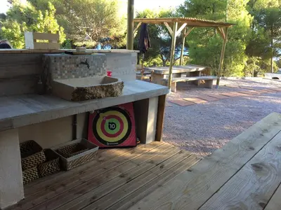 a wooden deck with a sink and a picnic table at Tente Lodge Bord de Mer in Coti-Chiavari