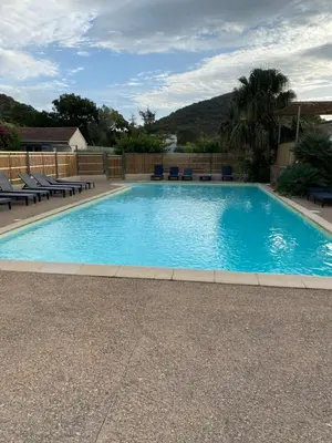 a large blue swimming pool with chairs around it at Marina Di Fautea in Olmucciu