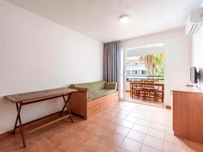 a living room with a couch and a table at Vacancéole - Résidence Sognu di Rena in San-Nicolao