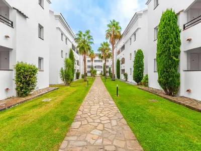 a walkway between two white buildings at Vacancéole - Résidence Sognu di Rena in San-Nicolao