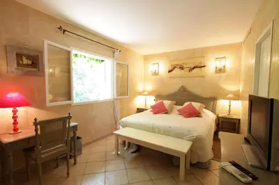 a bedroom with a bed and a desk and a television at Villas les Residences de Scaglione in Porticcio