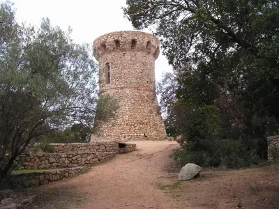 a brick tower sitting next to a stone wall at Villas les Residences de Scaglione in Porticcio