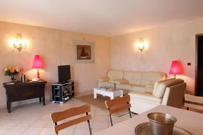 a living room with a couch and a tv at Villas les Residences de Scaglione in Porticcio