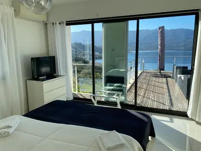 a bedroom with a large window with a view of a deck at Casaluce in Casaglione