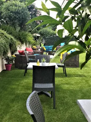 a table and chairs sitting on the grass at Hotel Maquis et Mer in Sari Solenzara