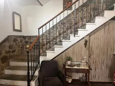 a living room with a chair and a staircase at Hotel Maquis et Mer in Sari Solenzara