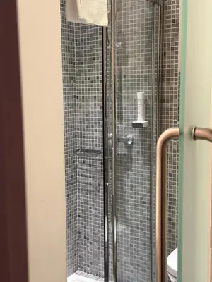 a shower with a glass door in a bathroom at Hotel Maquis et Mer in Sari Solenzara