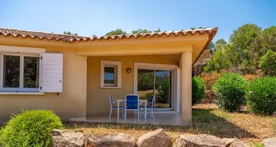 a small house with a table and chairs on a patio at Résidence Odalys San Martinu in Sainte-Lucie de Porto-Vecchio