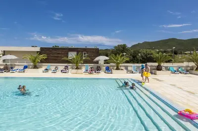 a group of people in the swimming pool at a resort at Résidence Odalys Les Villas de Bel Godère in Belgodère