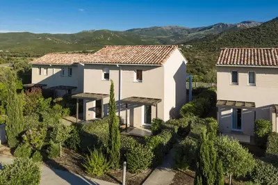an aerial view of two houses with mountains in the background at Résidence Odalys Les Villas de Bel Godère in Belgodère