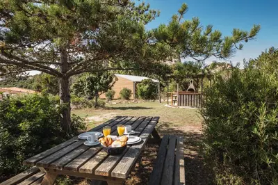 a picnic table with a bowl of fruit on it at Sapa Di Cala in Bonifacio
