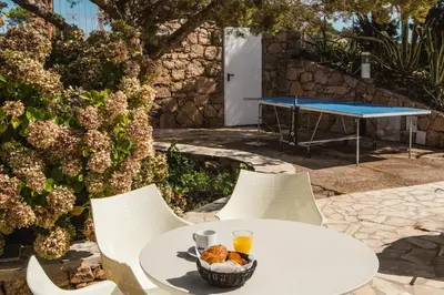a table and chairs with a bowl of food on it at Sapa Di Cala in Bonifacio