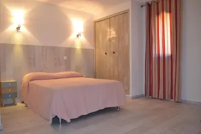 a bedroom with a bed and a dresser in it at Sapa Di Cala in Bonifacio