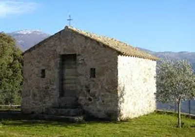 an old stone church with a cross on the front at Auberge de Jeunesse Chez Mc Donald in Zevaco