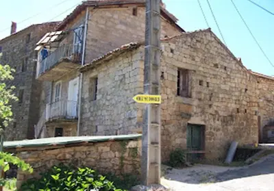 an old brick building with a street sign in front of it at Auberge de Jeunesse Chez Mc Donald in Zevaco