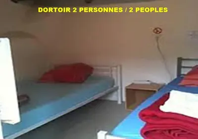 a bedroom with a bed with a red pillow on it at Auberge de Jeunesse Chez Mc Donald in Zevaco