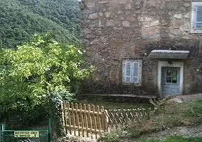 a brick house with a gate and a fence at Auberge de Jeunesse Chez Mc Donald in Zevaco