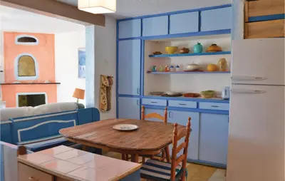 a kitchen with blue cabinets and a wooden table at Lovely Apartment In Serra Di Ferro in Serra-di-Ferro