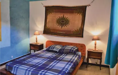 a bedroom with a blue and white plaid bed with two lamps at Lovely Apartment In Serra Di Ferro in Serra-di-Ferro