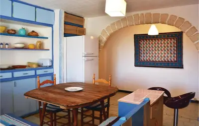 a kitchen with a wooden table and a refrigerator at Lovely Apartment In Serra Di Ferro in Serra-di-Ferro