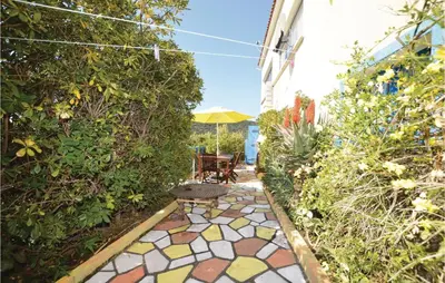 a patio with a table and a bench in a garden at Lovely Apartment In Serra Di Ferro in Serra-di-Ferro