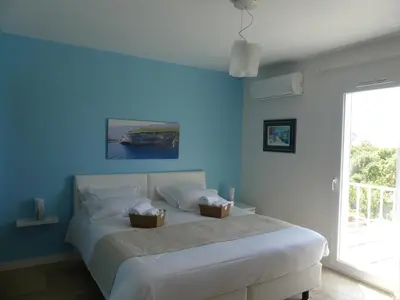 a blue bedroom with a bed with two baskets on it at Maison d' Hôtes L'Aria Mezzana in Sainte-Lucie de Porto-Vecchio