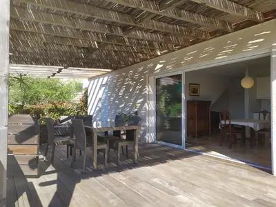 a patio with a table and chairs on a deck at Maison d' Hôtes L'Aria Mezzana in Sainte-Lucie de Porto-Vecchio